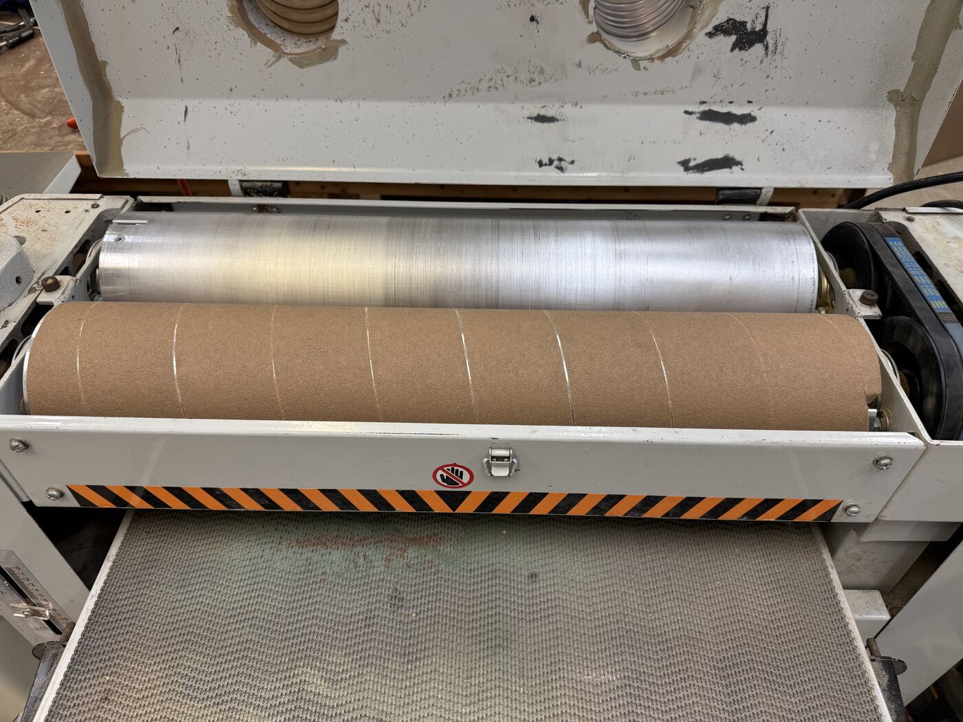 Finished abrasive strip wrapped around the sanding drum in a clean, evenly-spaced spiral.